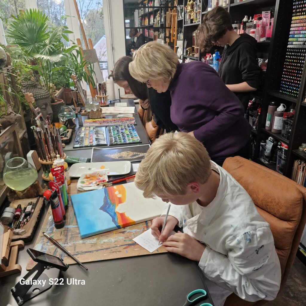 Participants de différentes générations travaillant sur leurs projets, entourés de matériel artistique à l’Atelier Carré d’Art’s.